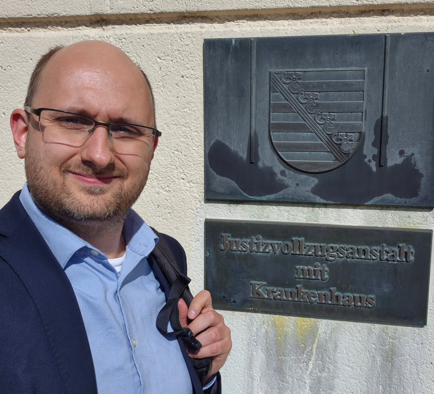 Rick Ulbricht vor dem Schild Justizvollzugsanstalt Leipzig mit Krankenhaus
